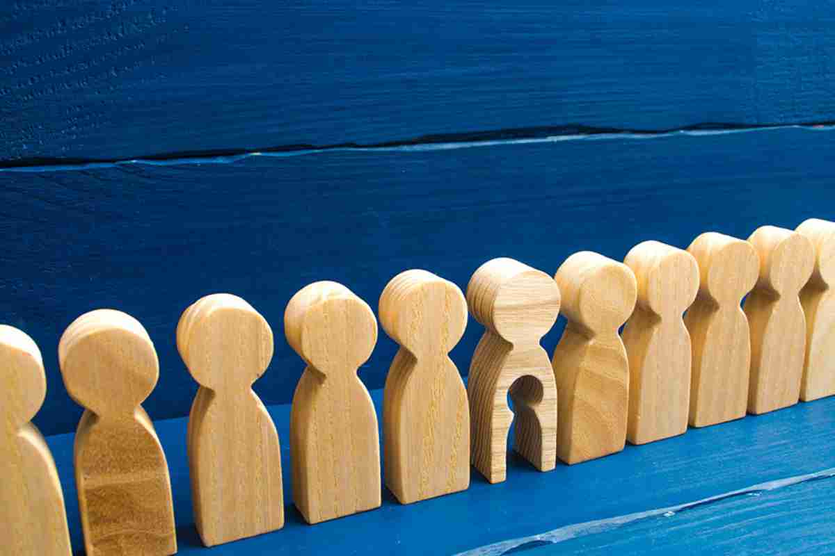 © Andrii Yalanskyi - stock.adobe.com Holzfiguren in einer Reihe, eine hat ein ausgeschnittenes Kind